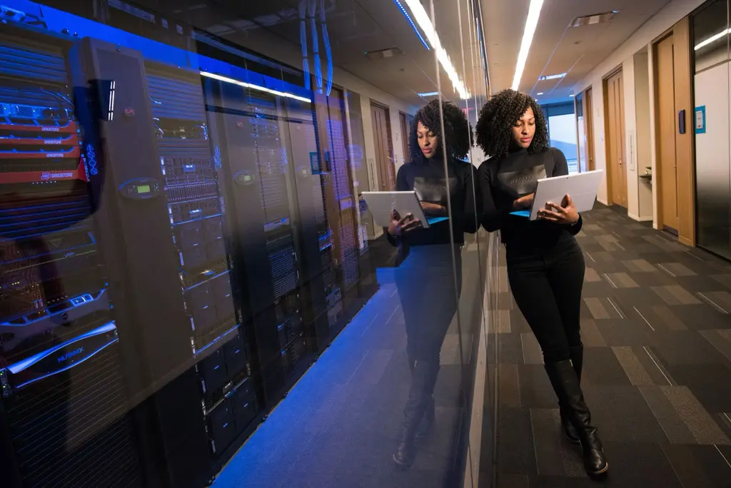 วิศวกรถือแล็ปท็อปตรวจสอบระบบข้างตู้แร็คใน Data Center